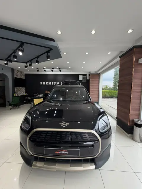 Premium Car Care duvarı önünde araç